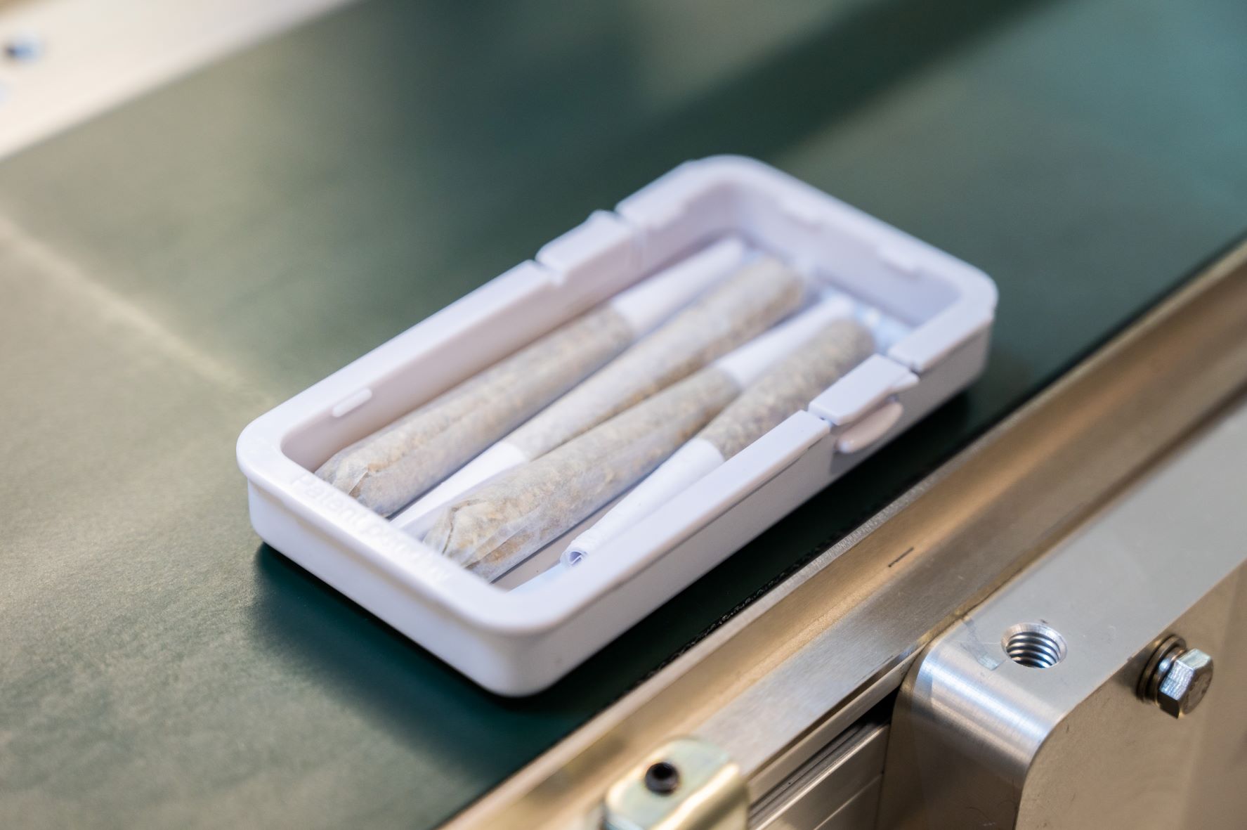 Placement of pre-rolled cannabis joints in a set configuration and orientation within a tray.